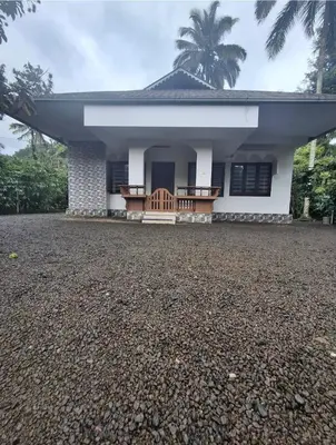 a house with a gravel driveway in front of it at Winter Valley Homestay in Vythiri