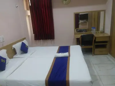 a room with a bed and a desk and a kitchen at North star in Mysore