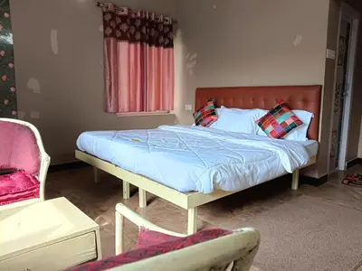 a bedroom with a bed and a chair at Meadows Mountain Villa in Ooty