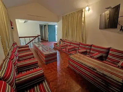 a living room with several couches in a room at Meadows Mountain Villa in Ooty