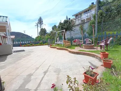 a playground with chairs and a swing at Meadows Mountain Villa in Ooty