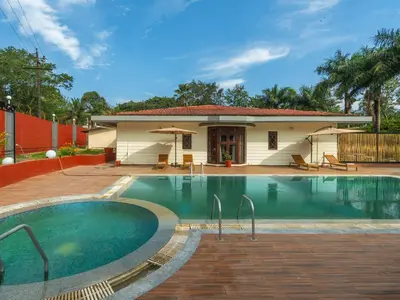 a swimming pool in front of a house at The Hosteller Bam Coorg in Madikeri
