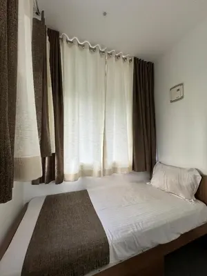 a small bed in a room with a window at Honeyrock Farm Resort by Skybz in Kanthalloor