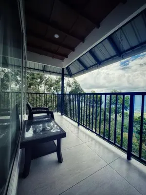 a balcony with a bench and a view of the water at Honeyrock Farm Resort by Skybz in Kanthalloor