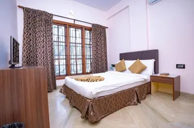 a bedroom with a large bed and a television in it at Sree Guruvayur Inn in Guruvāyūr