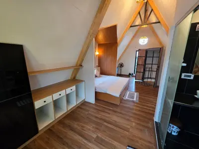 a small bedroom with a bed and wooden floors at The Gable in Seringapatam
