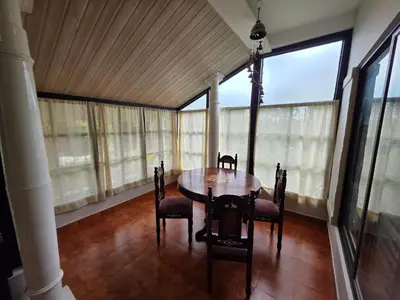 a dining room with a table and chairs and windows at The Gable in Seringapatam