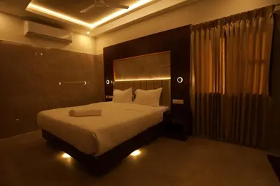 a bedroom with a large bed with lights on it at Arthana Residency Hotel