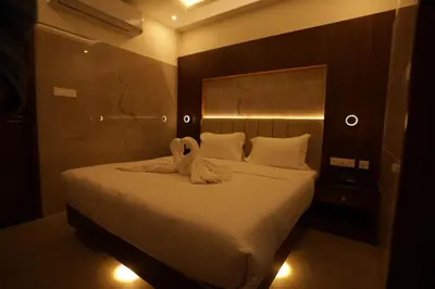 a bedroom with a bed with a towel on it at Arthana Residency Hotel