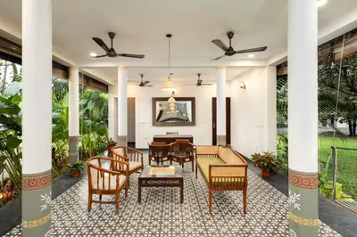 a living room with chairs and a table at Eka in Kodungallūr
