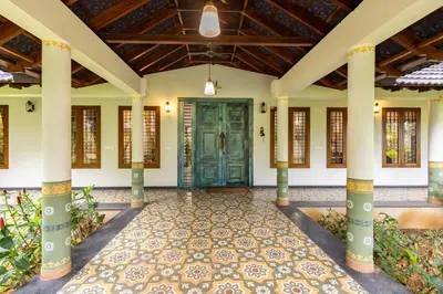 an entrance to a house with a green door at Eka in Kodungallūr