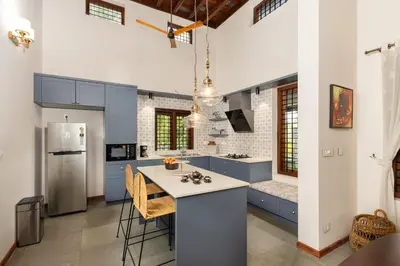 a kitchen with blue cabinets and a kitchen island at Eka in Kodungallūr
