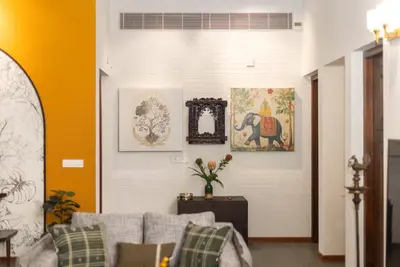 a living room with a couch and paintings on the wall at Eka in Kodungallūr