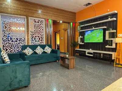 a living room with a couch and a television at Hamsa Farmstay Mysore, Campfire, Bbq, Cricket in Mysore