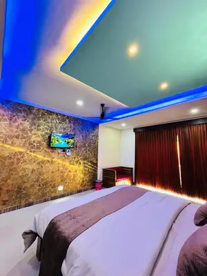 a bedroom with a large bed and a tv on a wall at Private Pool Villa by Green View in Vythiri