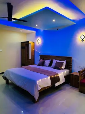 a bedroom with a large bed with blue lighting at Private Pool Villa by Green View in Vythiri