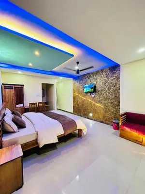 a bedroom with a bed and a tv on a wall at Private Pool Villa by Green View in Vythiri