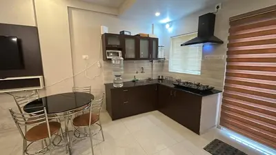 a kitchen with a table and chairs in a kitchen at Divin Le Divine 150 meter to temple in Guruvāyūr