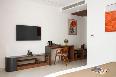 a room with a desk and a tv on a wall at CASTELO Inn in Nedumbassery