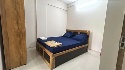 a small bed in a room with blue pillows at Divin Kalpaka 150 meter to temple in Guruvāyūr