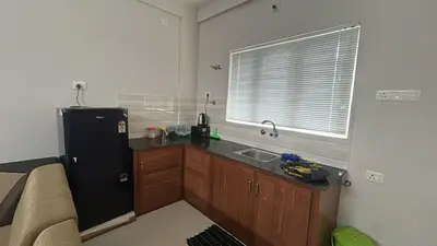 a kitchen with a black refrigerator and a sink at Divin Kalpaka 150 meter to temple in Guruvāyūr