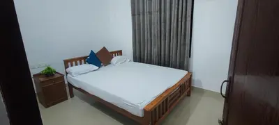 a small bedroom with a bed and a window at Vedic Nirvana Home Stays & Rooms in Irinjālakuda