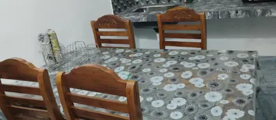 a dining room table with chairs and a tablecloth with flowers at Misty plaza in Vattavada