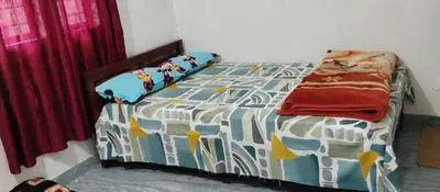 a bedroom with a bed with a comforter on it at Misty plaza in Vattavada
