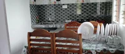 a dining room table with chairs and plates on it at Misty plaza in Vattavada