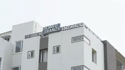 a white building with a sign on the top of it at DEJAVU TRANZS - Trishul in Coimbatore