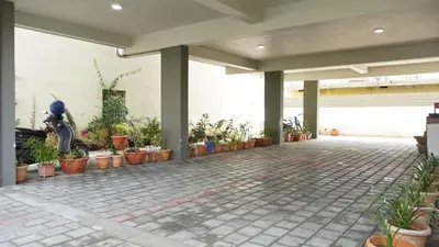 a patio with potted plants on the side of a building at DEJAVU TRANZS - Trishul in Coimbatore