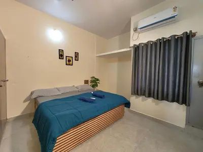 a bedroom with a bed with blue sheets and a window at Galaxy Homestay Mysore 4bhk - Family friendly in Mysore