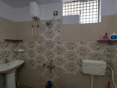 a bathroom with a toilet and a sink with roses wallpaper at Galaxy Homestay Mysore 4bhk - Family friendly in Mysore