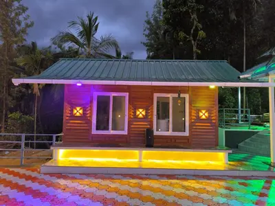 a small wooden house with colorful lights on it at wild casa in Kanthalloor