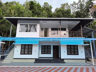 a house with a blue roof at wild casa in Kanthalloor