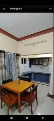 a kitchen with a wooden table and two chairs at PARK VIEW In MYSORE CITY in Mysore