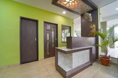a lobby with a reception desk and green walls at Chakraa Hotels in Coimbatore
