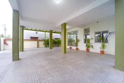 an empty building with green pillars and plants in it at Chakraa Hotels in Coimbatore