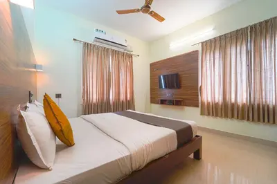 a bedroom with a bed and a television in it at Chakraa Hotels in Coimbatore