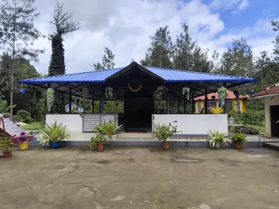 a pavilion with a blue roof with potted plants at Rising Surya Homestay in Kushālnagar