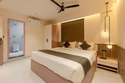 a bedroom with a large bed and a bathroom at Legacy Inn, Mysore in Mysore