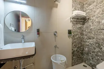 a bathroom with a sink and a toilet and a mirror at Legacy Inn, Mysore in Mysore