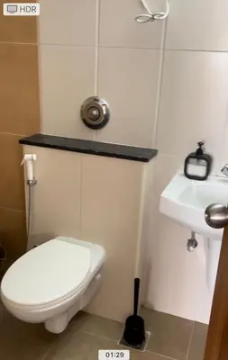 a bathroom with a white toilet and a sink at Aarav Stays in Mysore
