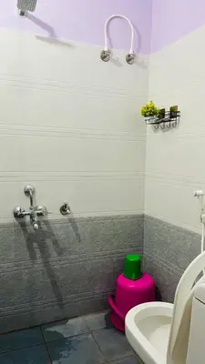 a bathroom with a sink and a green stool at Mysore Stopover in Mysore