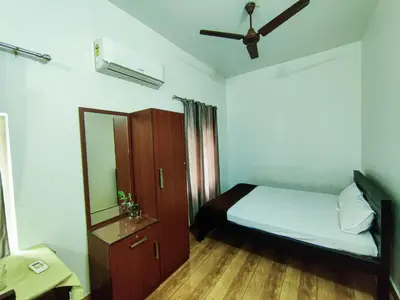 a small bedroom with a bed and a mirror at kadalundi Heritage in Vallikunnu