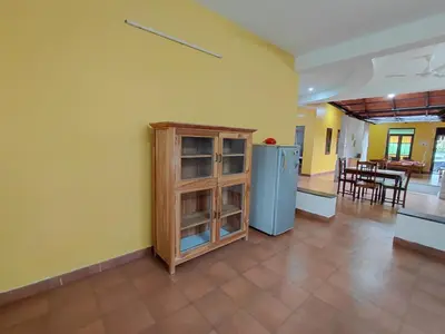 a kitchen with a refrigerator and a dining room at SHI's Chettinad Courtyard Villa a 3BHK near Adiyogi in Alāndurai
