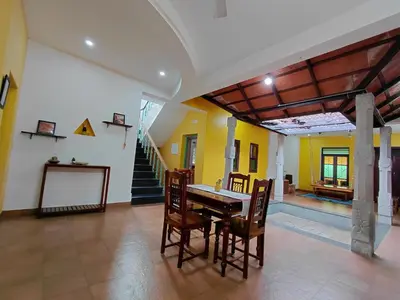 a dining room with a table and chairs and stairs at SHI's Chettinad Courtyard Villa a 3BHK near Adiyogi in Alāndurai