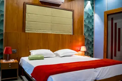 a bedroom with a large bed with a red blanket at Daya Village in Tirūrangādi