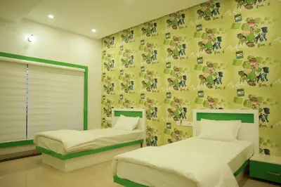 a bedroom with two beds and a wall with a pokemon wallpaper at The Glen By Bloobuck in Ambalavayal
