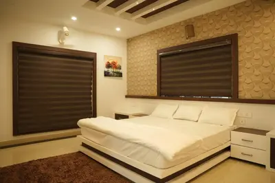 a bedroom with a large white bed and two windows at The Glen By Bloobuck in Ambalavayal